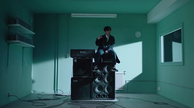 a man sitting on top of a stack of speakers