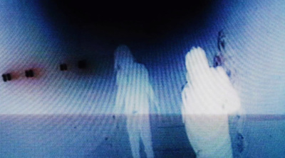 a blurry image of two people standing in a dark room