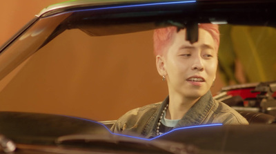 a man with pink hair sitting in a car