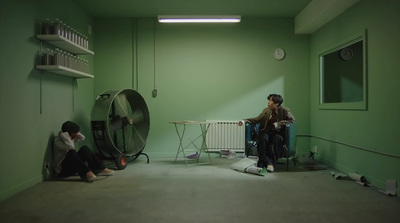 two people sitting in a room with a fan