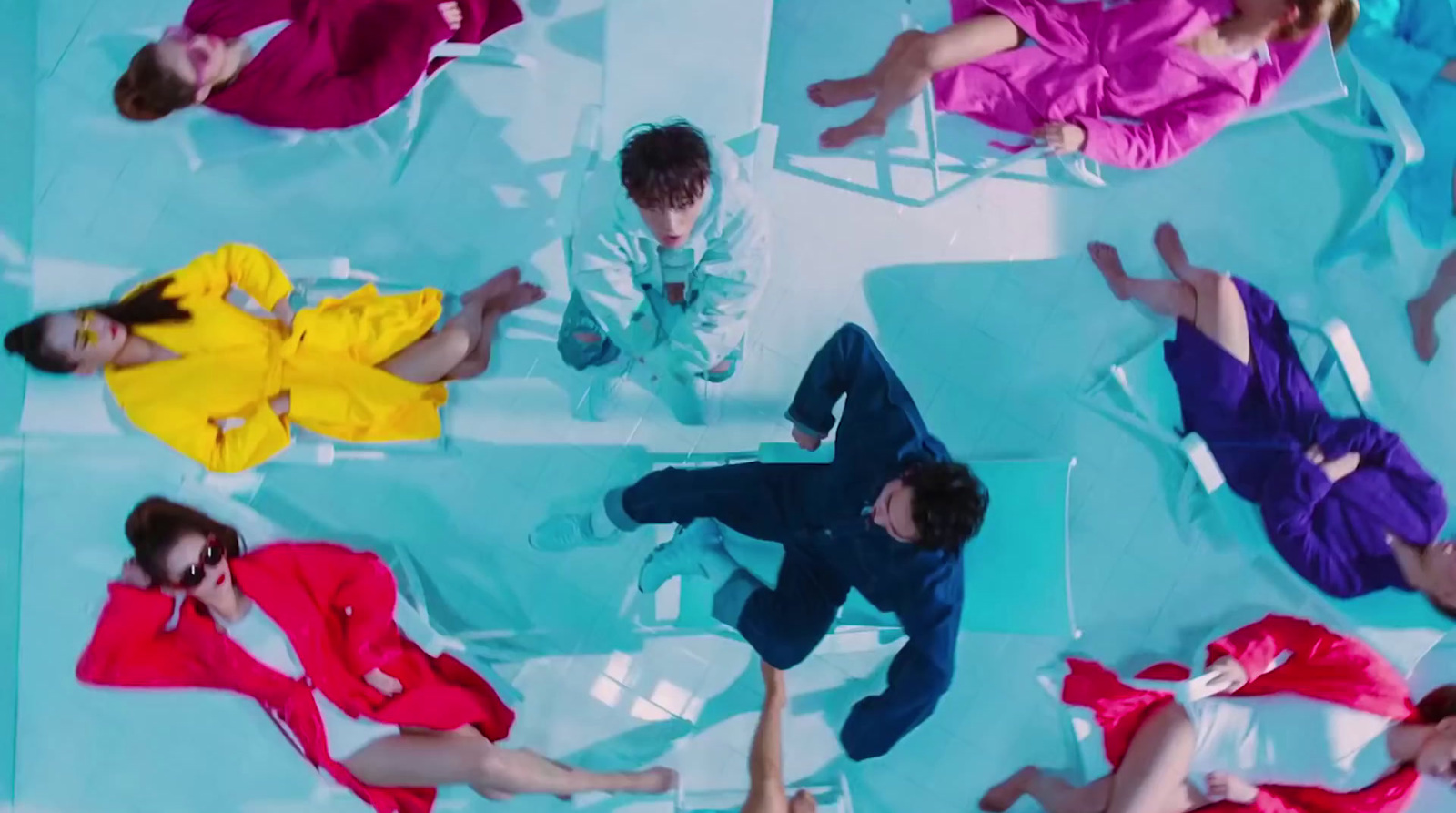 a group of people laying on top of a blue floor