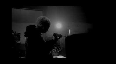 a person standing in a dark room holding a flower