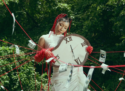 a woman in a white dress holding a large clock