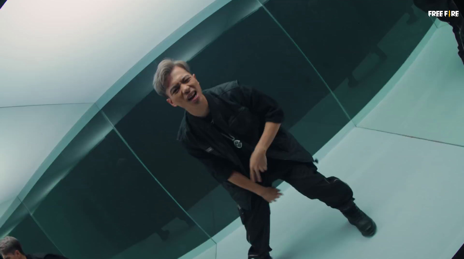 a man in a black shirt and black pants standing in front of a glass wall