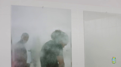 a man standing in front of a mirror in a bathroom