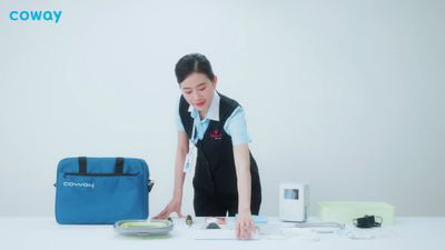 a woman standing over a table with a laptop