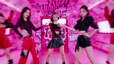 a group of women standing in front of a pink wall