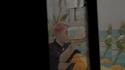 a man with pink hair taking a picture of himself in a mirror