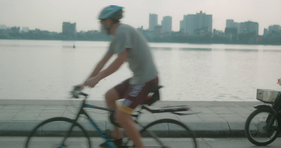 a man riding a bike next to a body of water