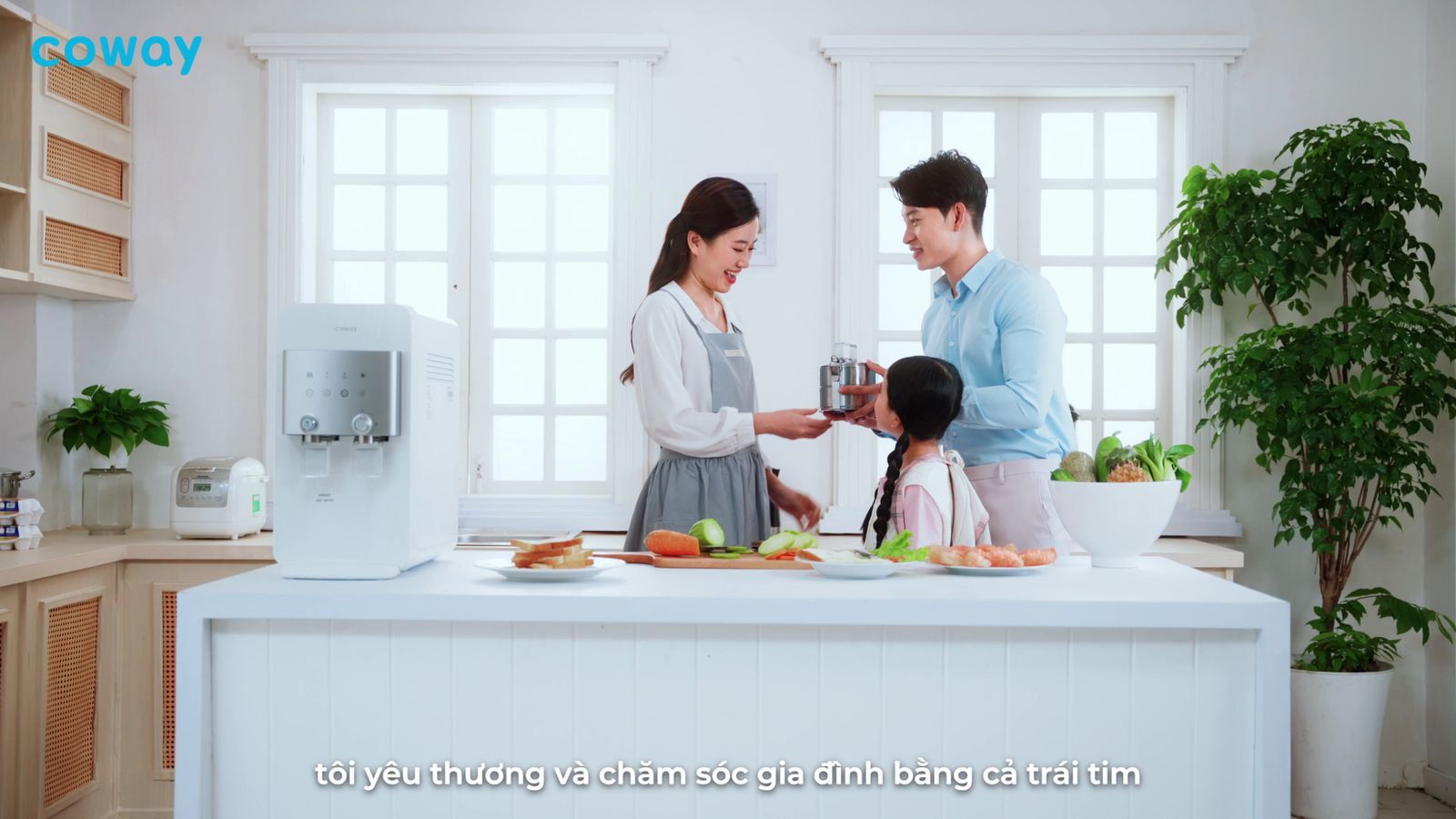 a man and woman standing in a kitchen with a child