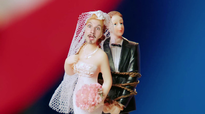 a figurine of a bride and groom on a blue and red background