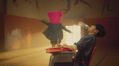 a man sitting at a desk with a pink teddy bear