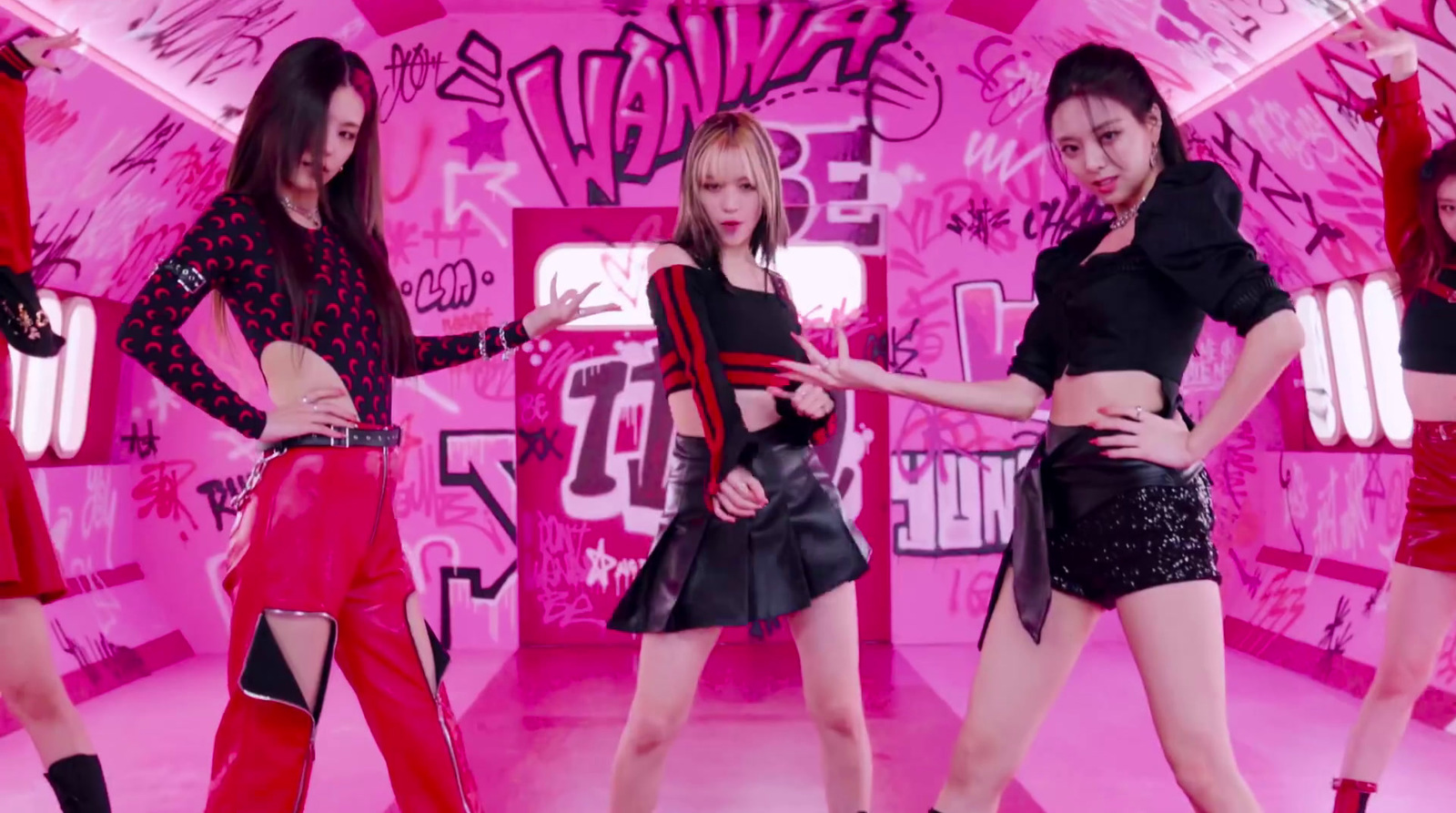 a group of girls standing in front of a pink wall