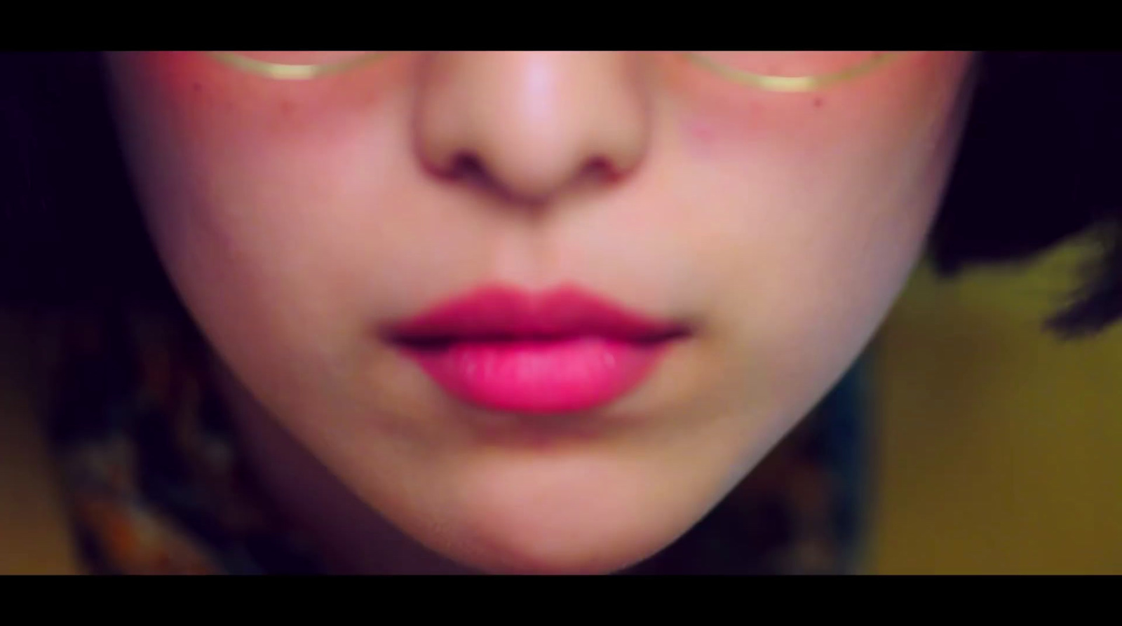 a close up of a woman's face with pink lipstick