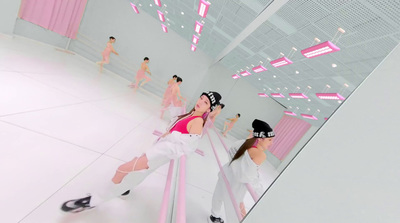 a woman in a pink top is dancing in a mirror