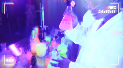 a man in a lab coat holding a flask of liquid