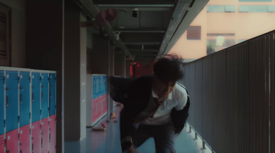 a man in a white shirt and tie is walking down a hallway