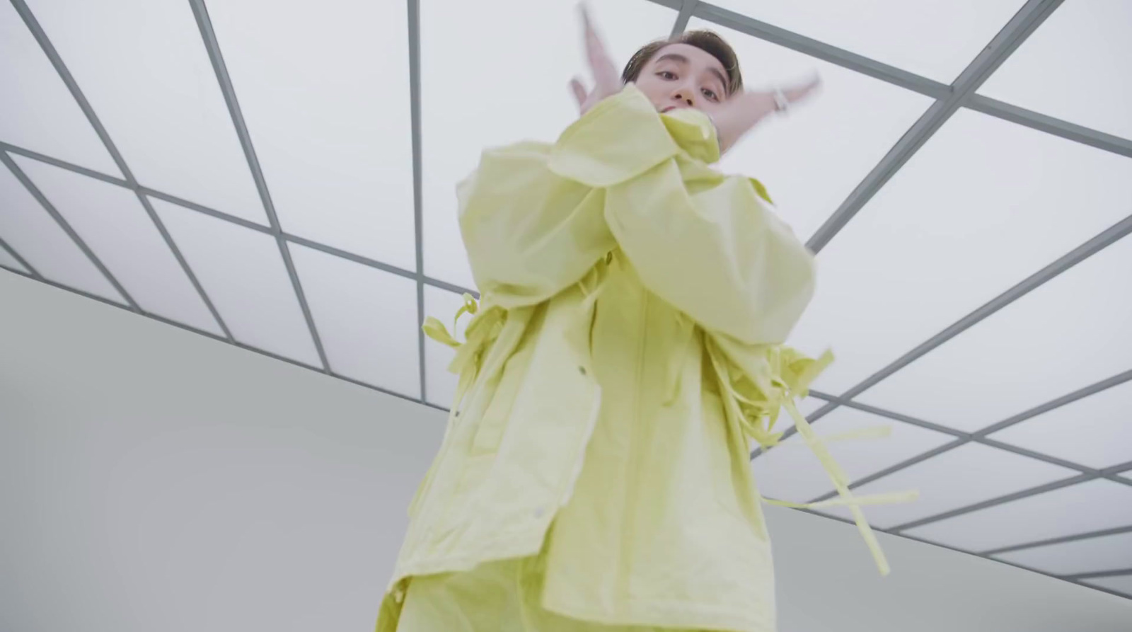 a woman in a yellow outfit standing under a metal structure