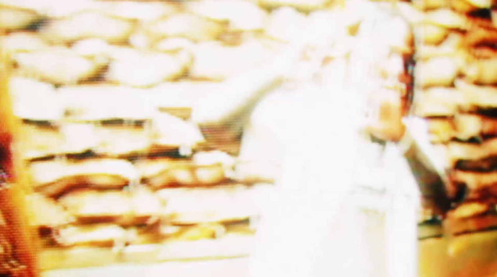 a blurry photo of a person standing in front of a display of donuts