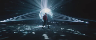 a woman standing in front of a disco ball