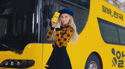 a woman standing next to a yellow bus