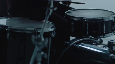 a person sitting in front of a drum set