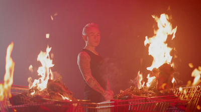 a woman standing next to a shopping cart on fire