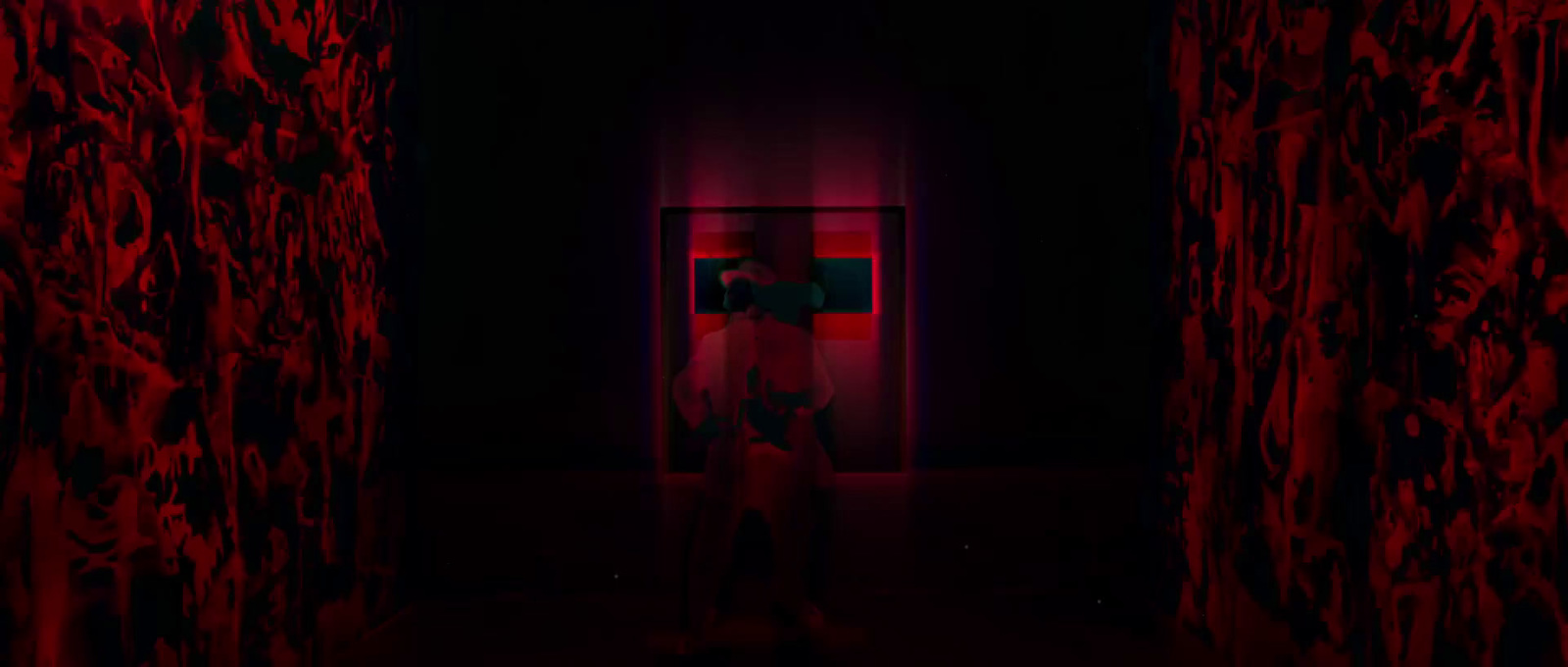 a person standing in a dark room with red curtains