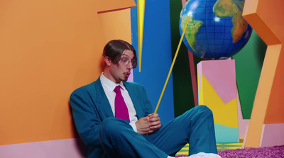 a man in a suit and tie sitting on the ground