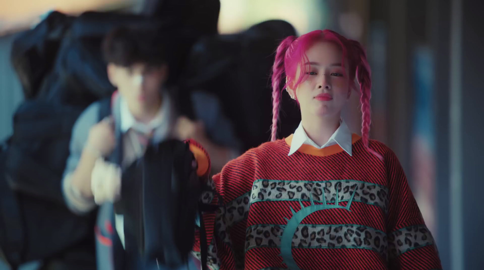 a woman with pink hair and a red sweater