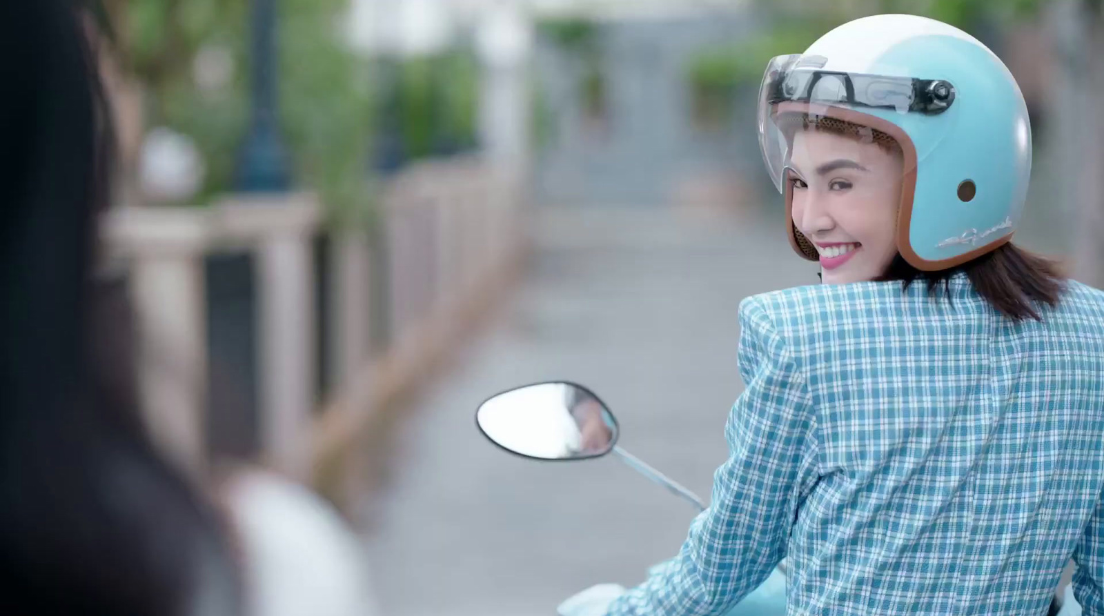 a young girl wearing a helmet on a scooter