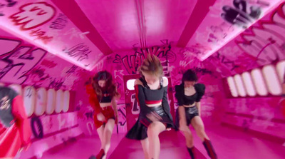 a group of women in a pink room with graffiti on the walls