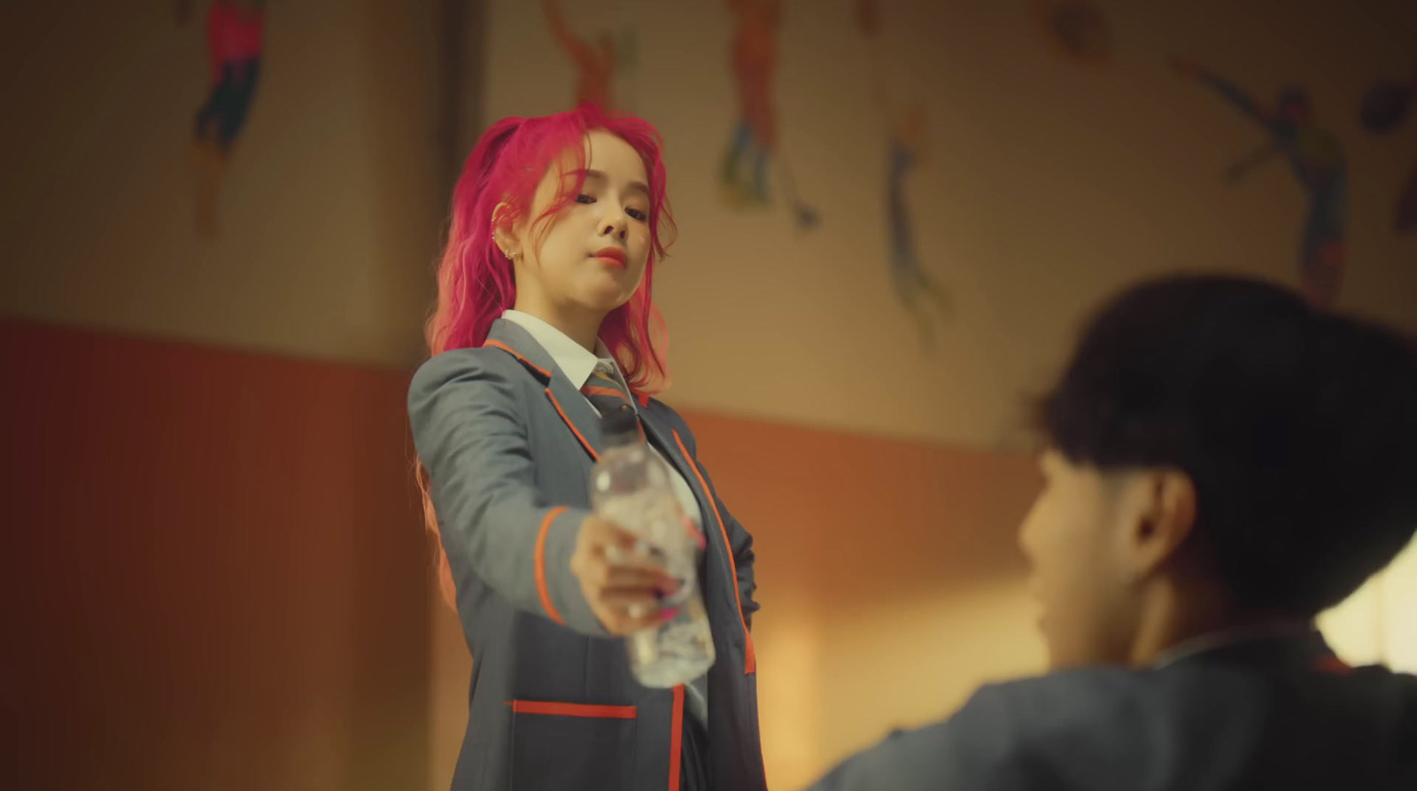 a woman with pink hair is holding a glass of water