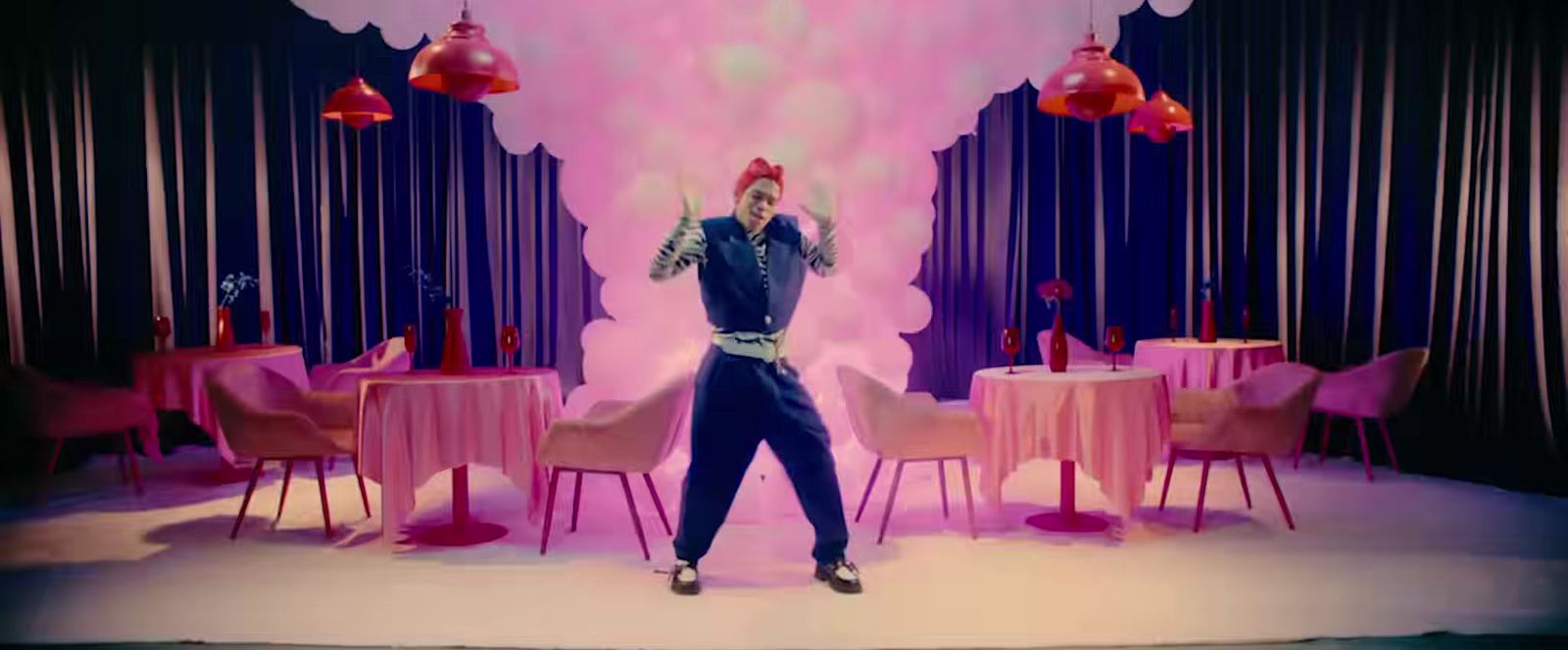 a man standing on top of a stage in front of a table