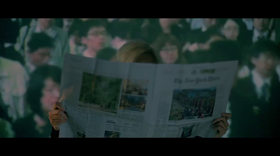 a woman reading a newspaper in front of a group of people