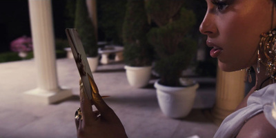 a woman in a white dress looking at a tablet