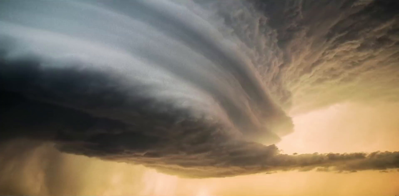 a large cloud is in the sky over a beach