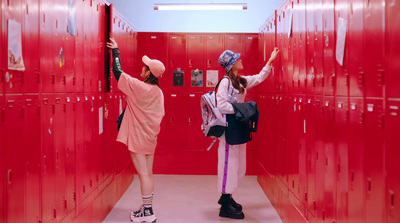 two women are standing in a red locker