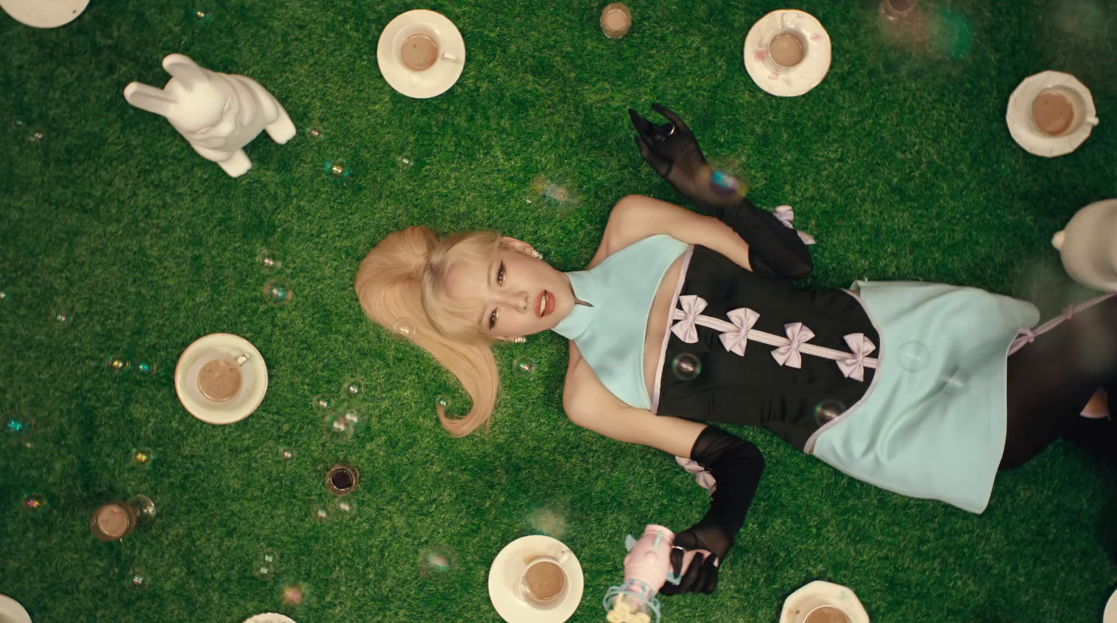 a woman laying on the ground surrounded by cups of coffee