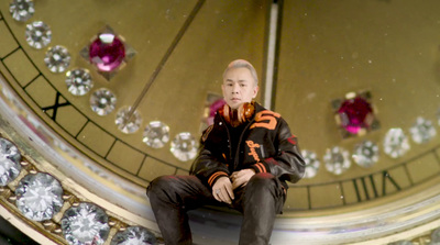 a man sitting on top of a large clock