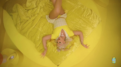 a woman laying on top of a yellow bed