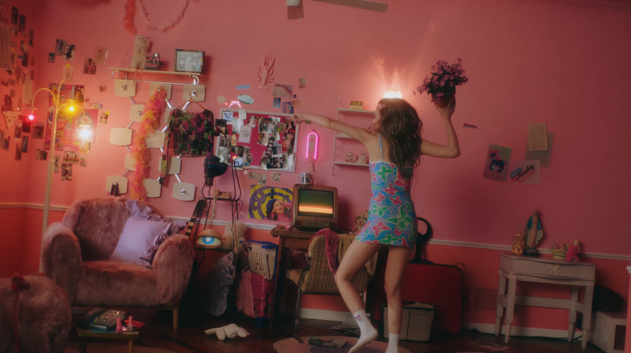 a woman standing in a room with pink walls