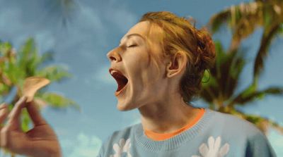 a woman holding a banana up to her mouth