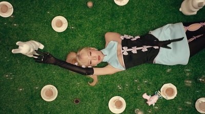 a woman laying on the ground with a hat and gloves on