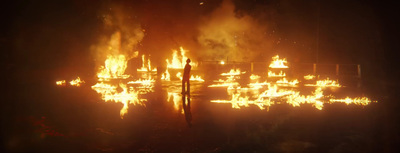 a man standing in front of a large fire