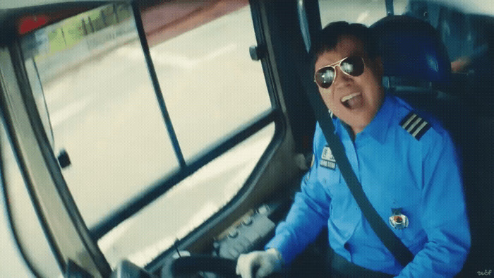 a man in a blue uniform sitting in a bus