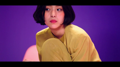 a woman sitting on top of a pink chair