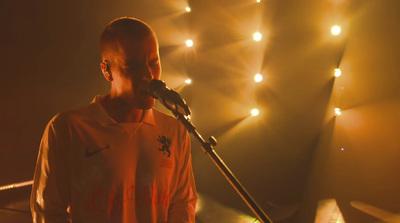 a man standing in front of a microphone on a stage