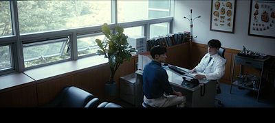 two men sitting at a desk in an office