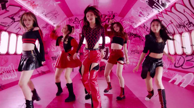 a group of young women dancing in a pink room